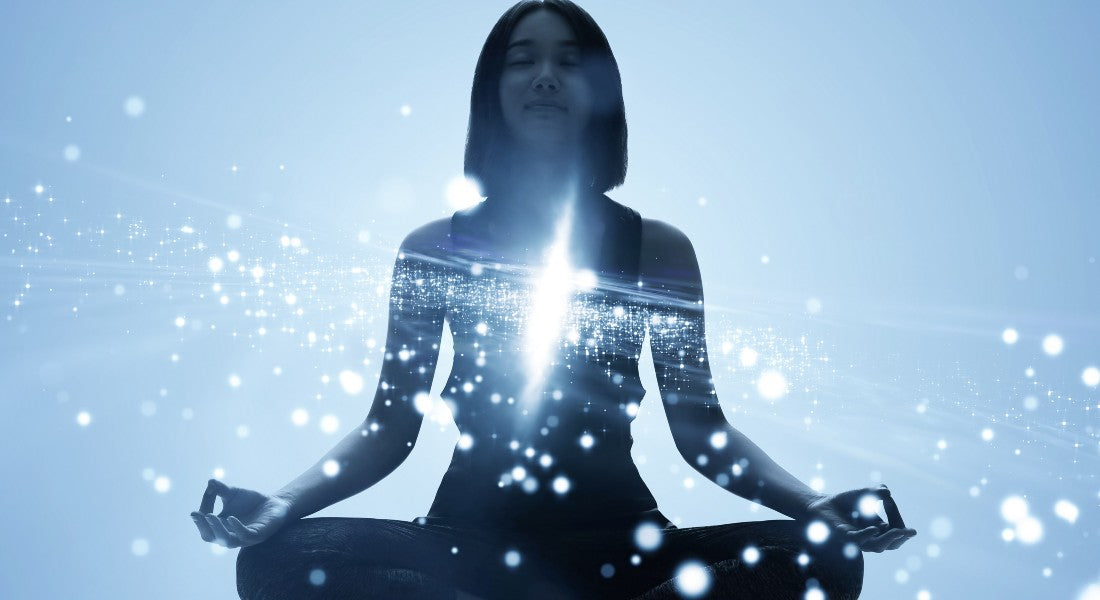 Woman in a meditative pose with a blue light effect on a light blue background.