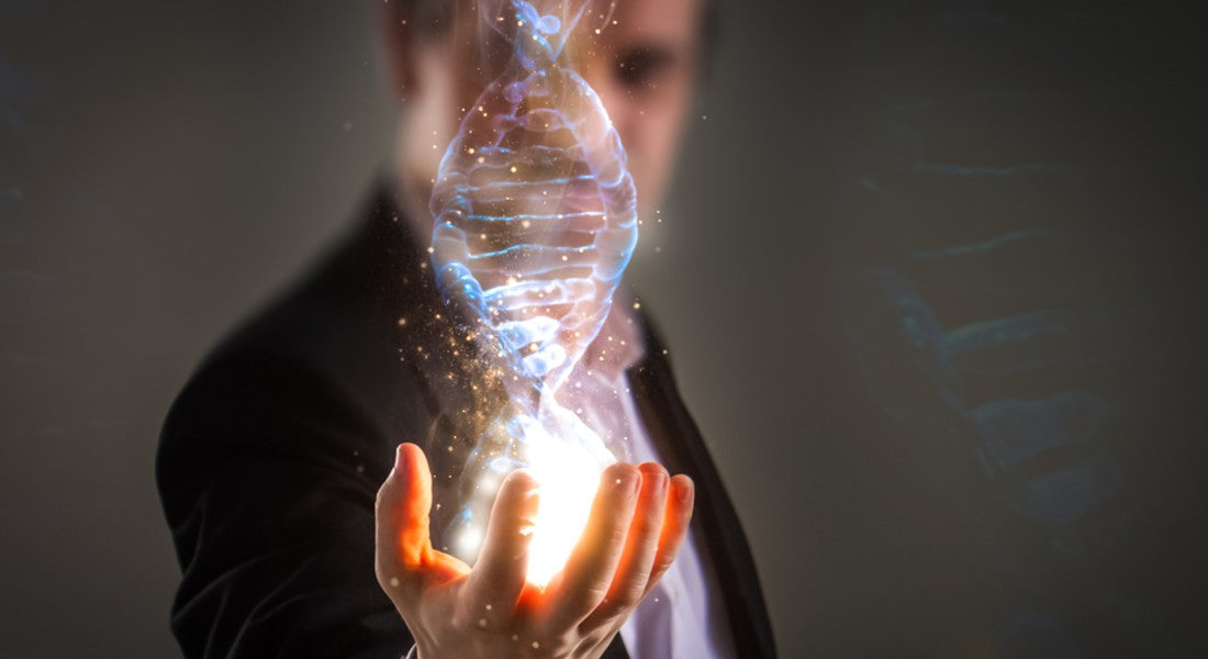Person holding a glowing DNA double helix in front of a dark background.