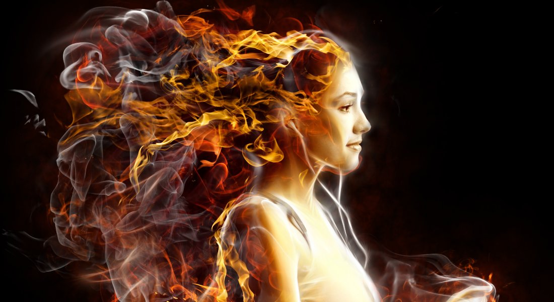 Woman with fiery hair against a dark background