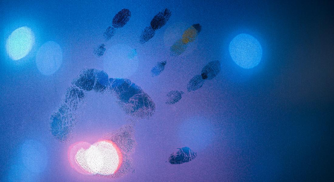 Handprint on glass with blue background representing energetic imprints.
