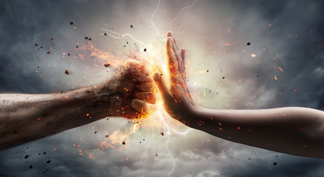 Two hands reaching towards each other with a glowing, fiery explosion between them against a dark background.