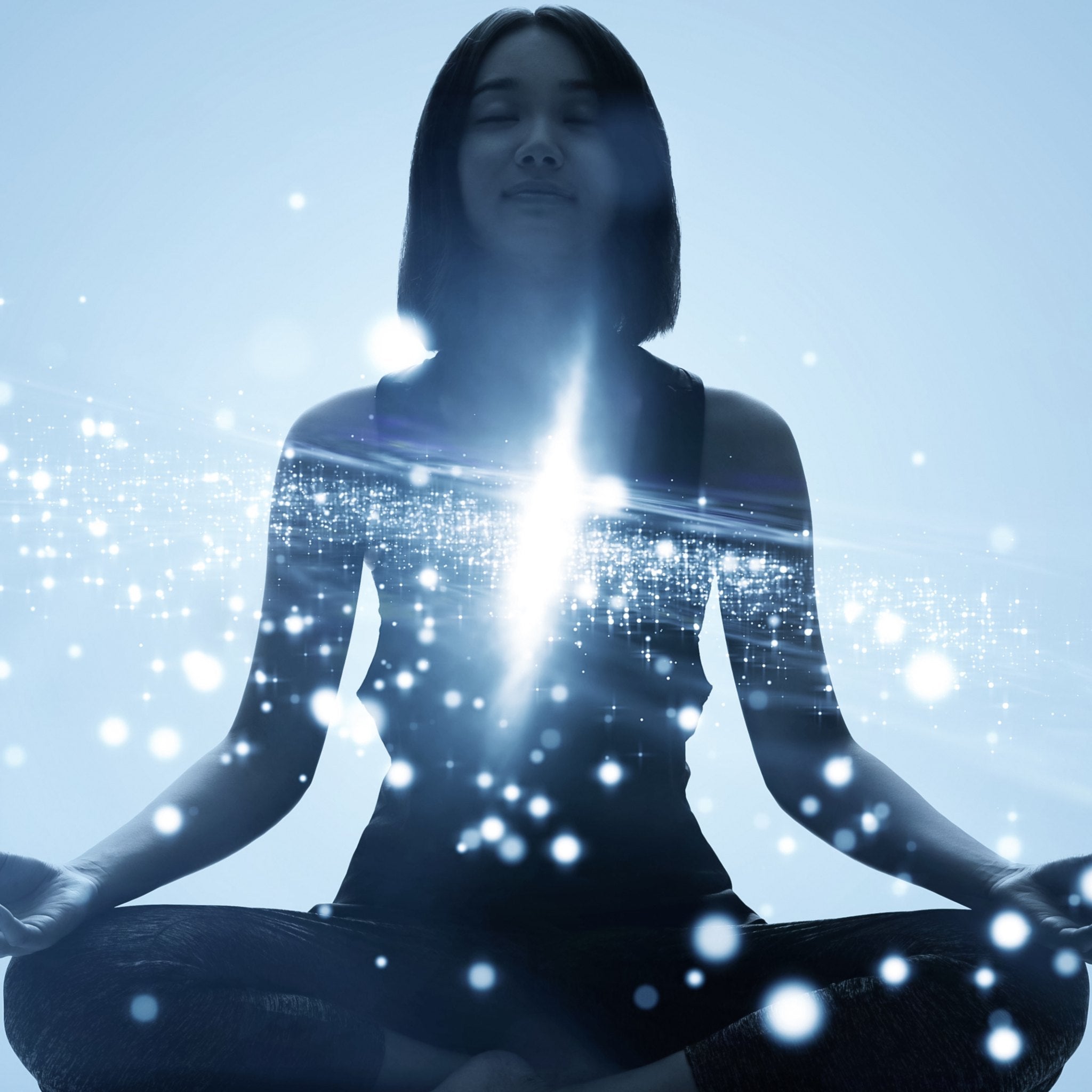 A silhouette of a young woman sitting in a meditative pose, with her heart centre illuminated by an intense burst of white light and sparkling, ethereal particles against a bright, light-blue background.