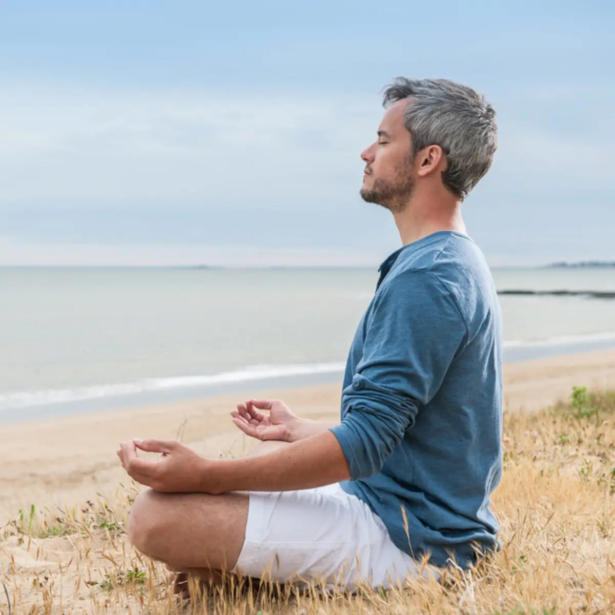 Attunement packages illustration: man meditating on beach.
