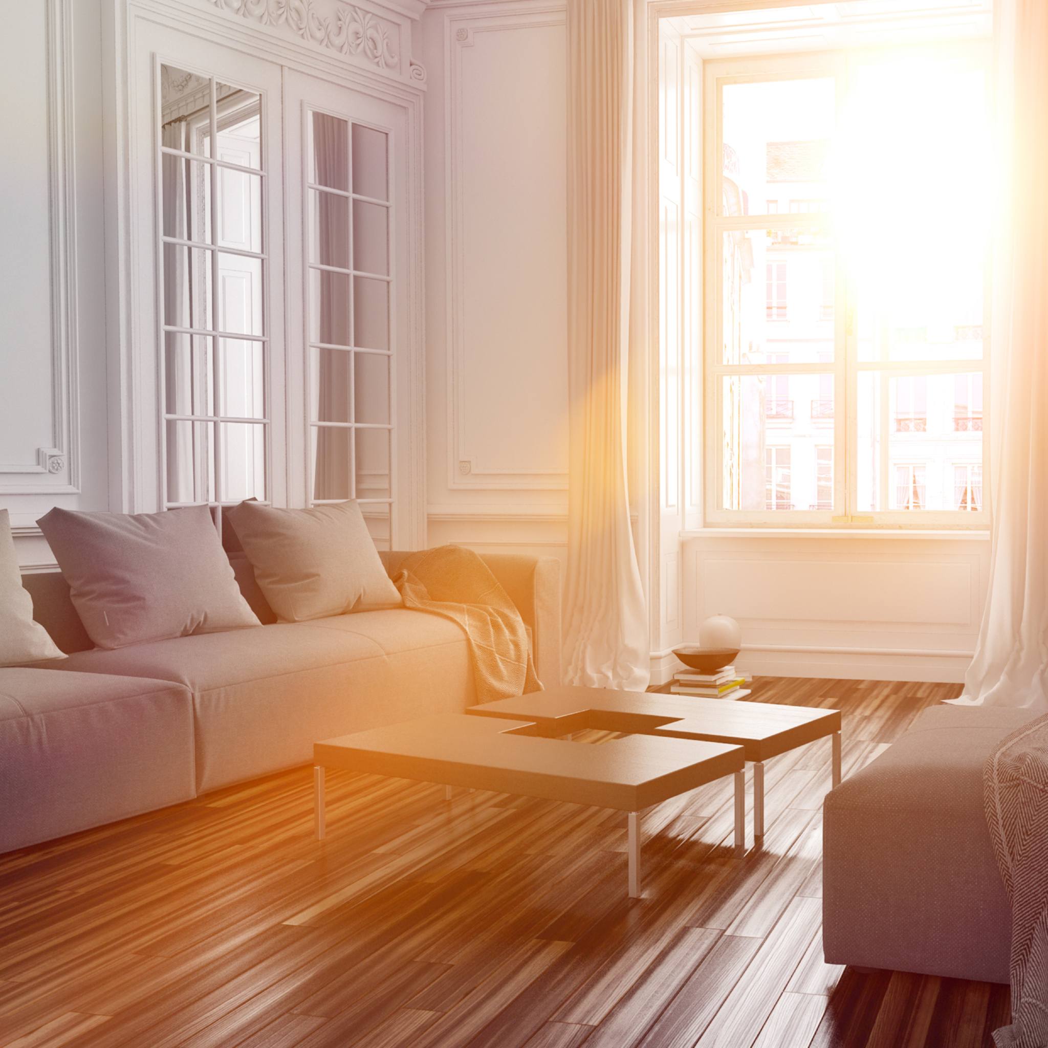 A bright, sunlit interior of a modern, white living room with elegant mouldings and hardwood floors, representing distant home space clearing.
