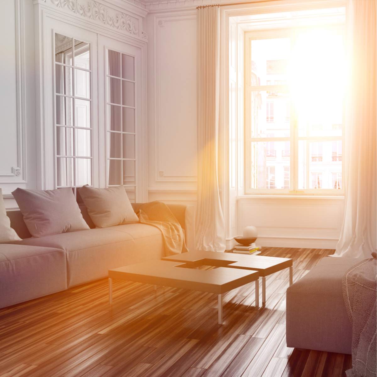 A bright, sunlit interior of a modern, white living room with elegant mouldings and hardwood floors, representing distant home space clearing.