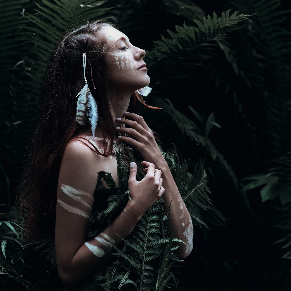 Person receiving ancestral healing energy in a dark forest setting.
