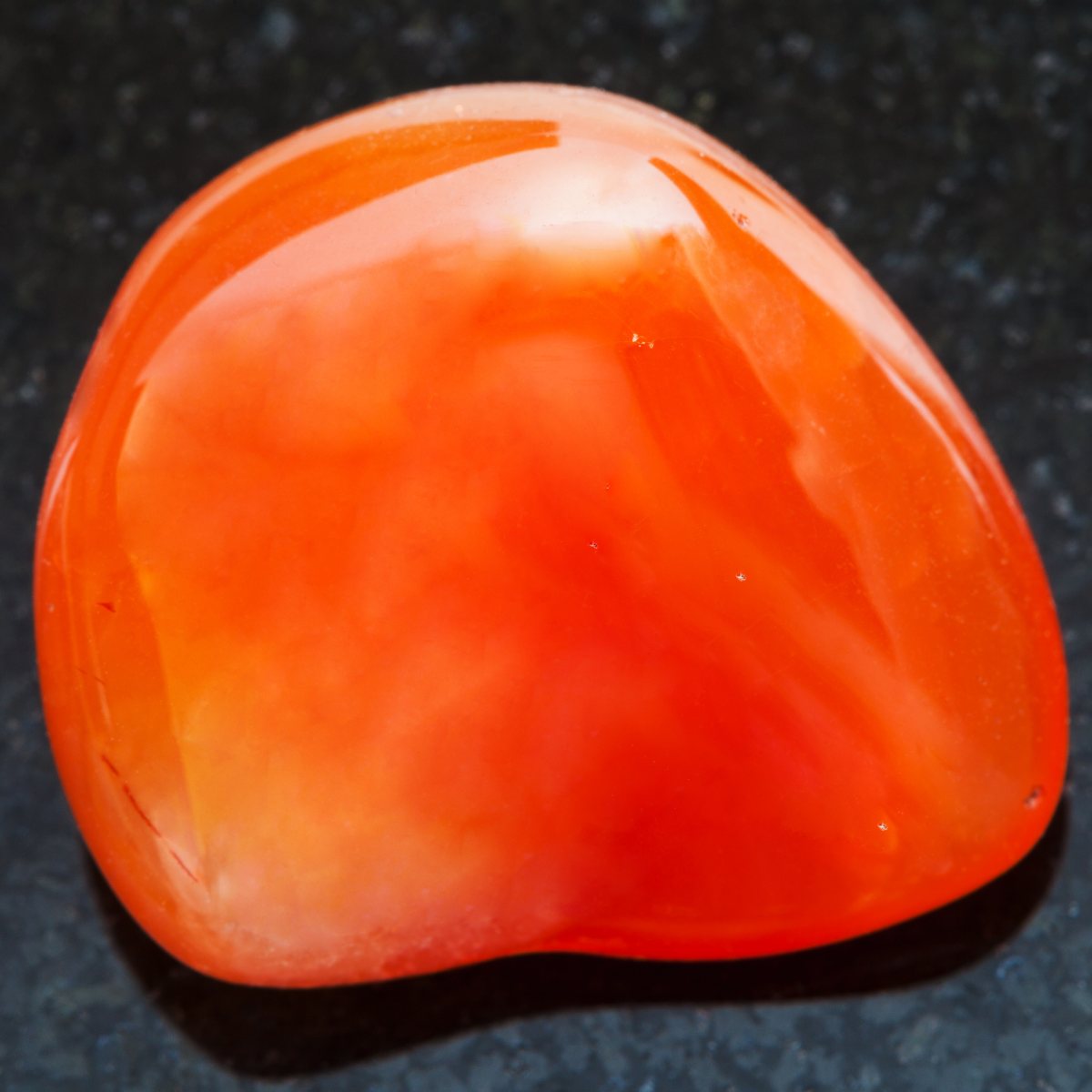 Orange carnelian crystal on a dark background.