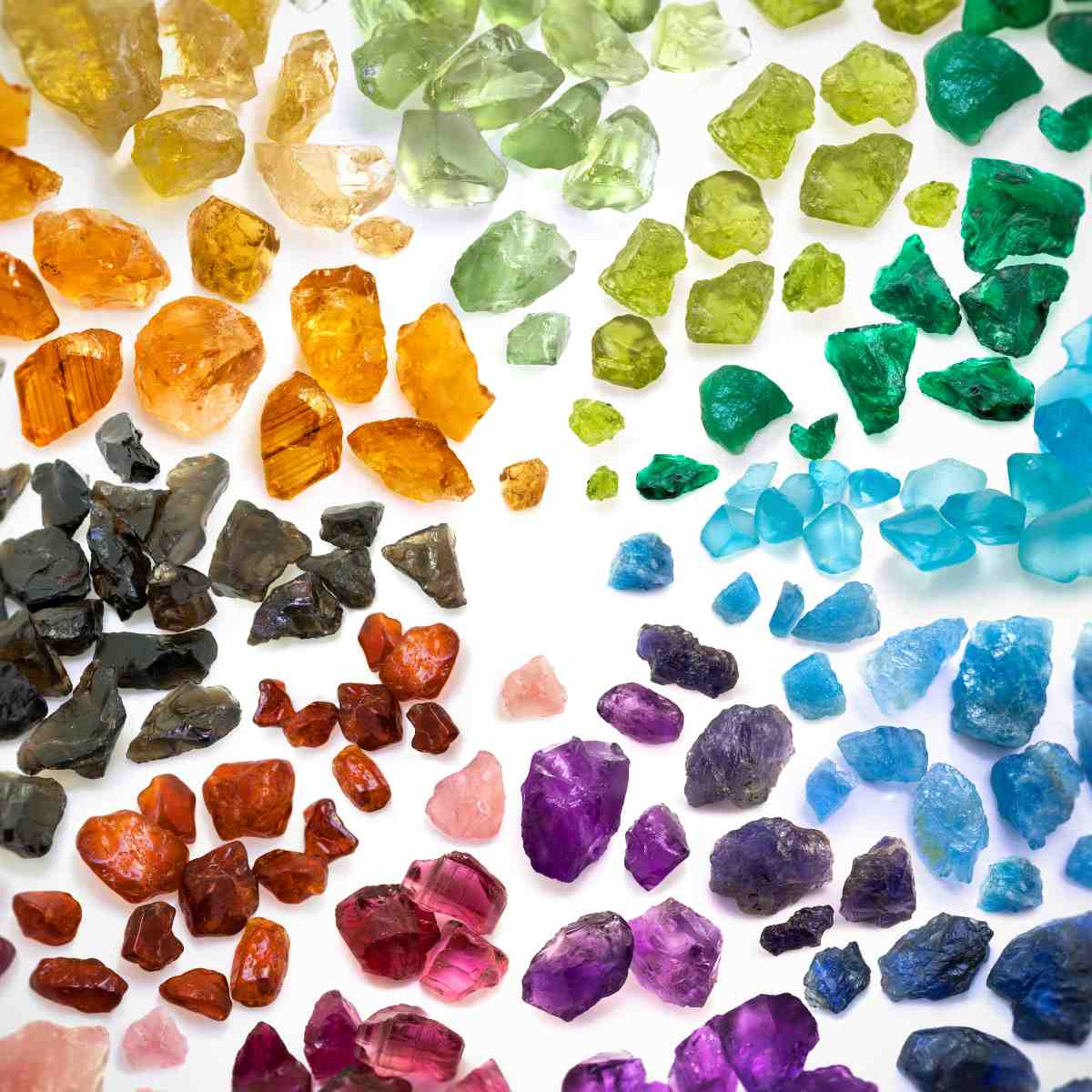Assorted coloured gemstones and crystals on a white background.