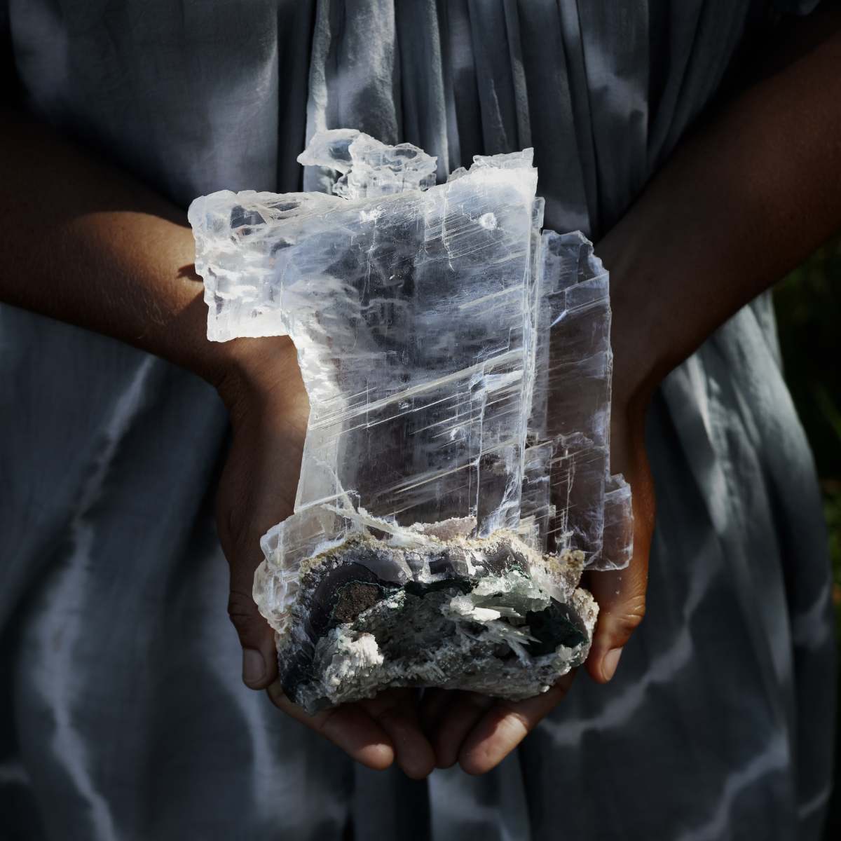 Person holding a large selenite crystal formation.