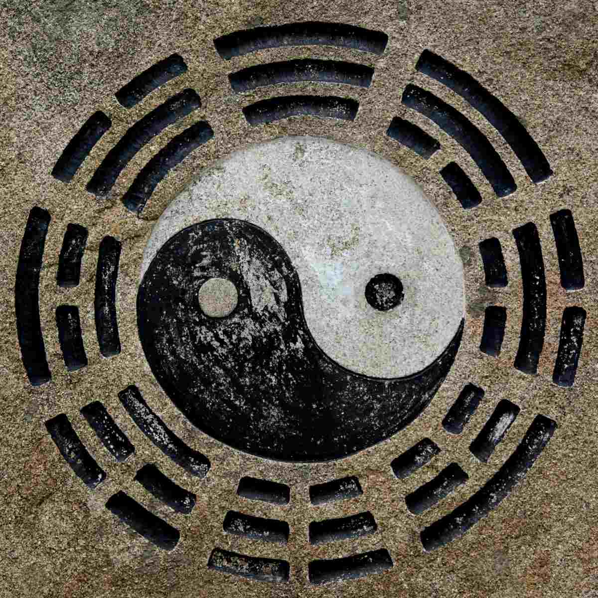 Yin and yang symbol on sand with八卦 (Bāguà) patterns symbolising Tao.
