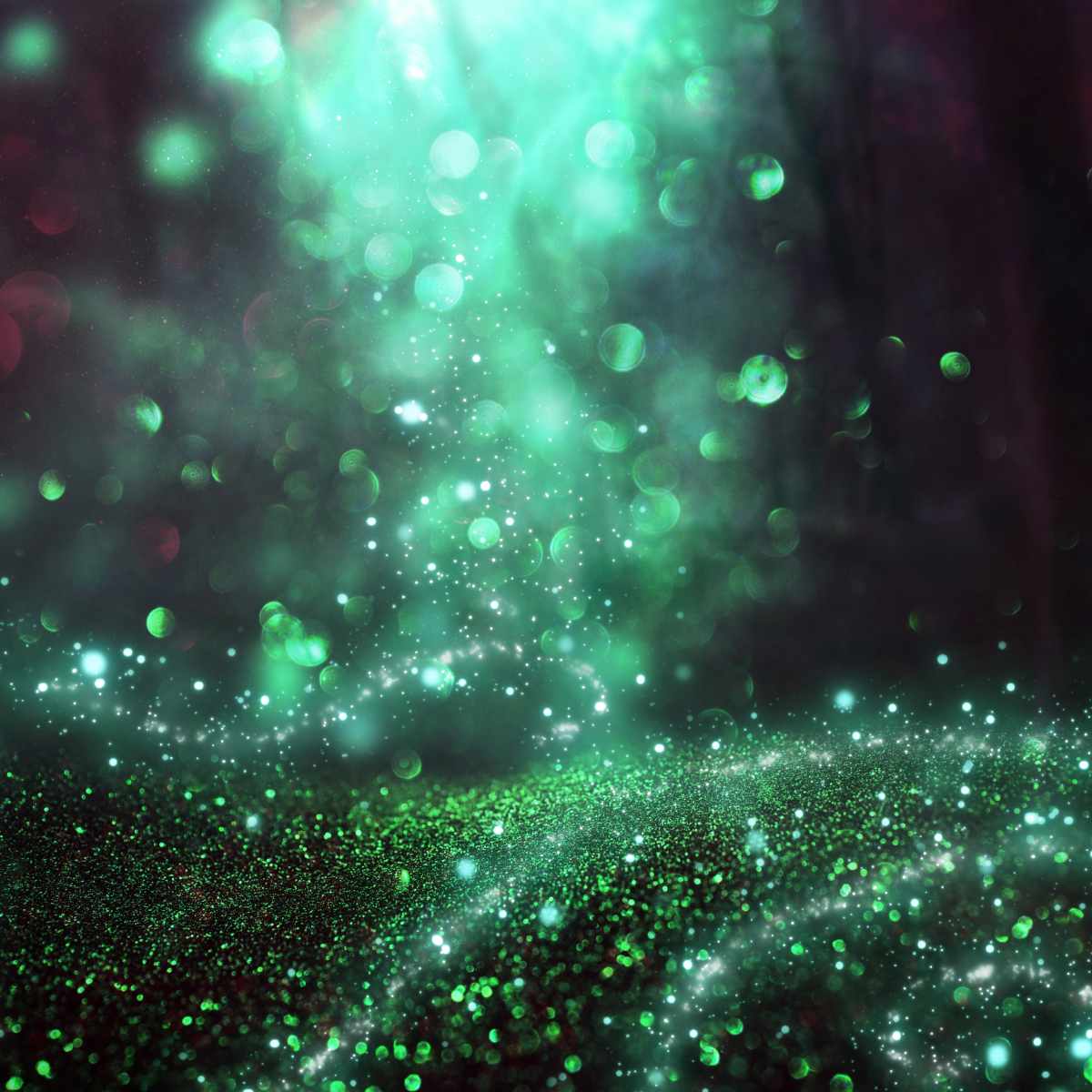 Green glittery texture representing earth fairy magic on a dark background.