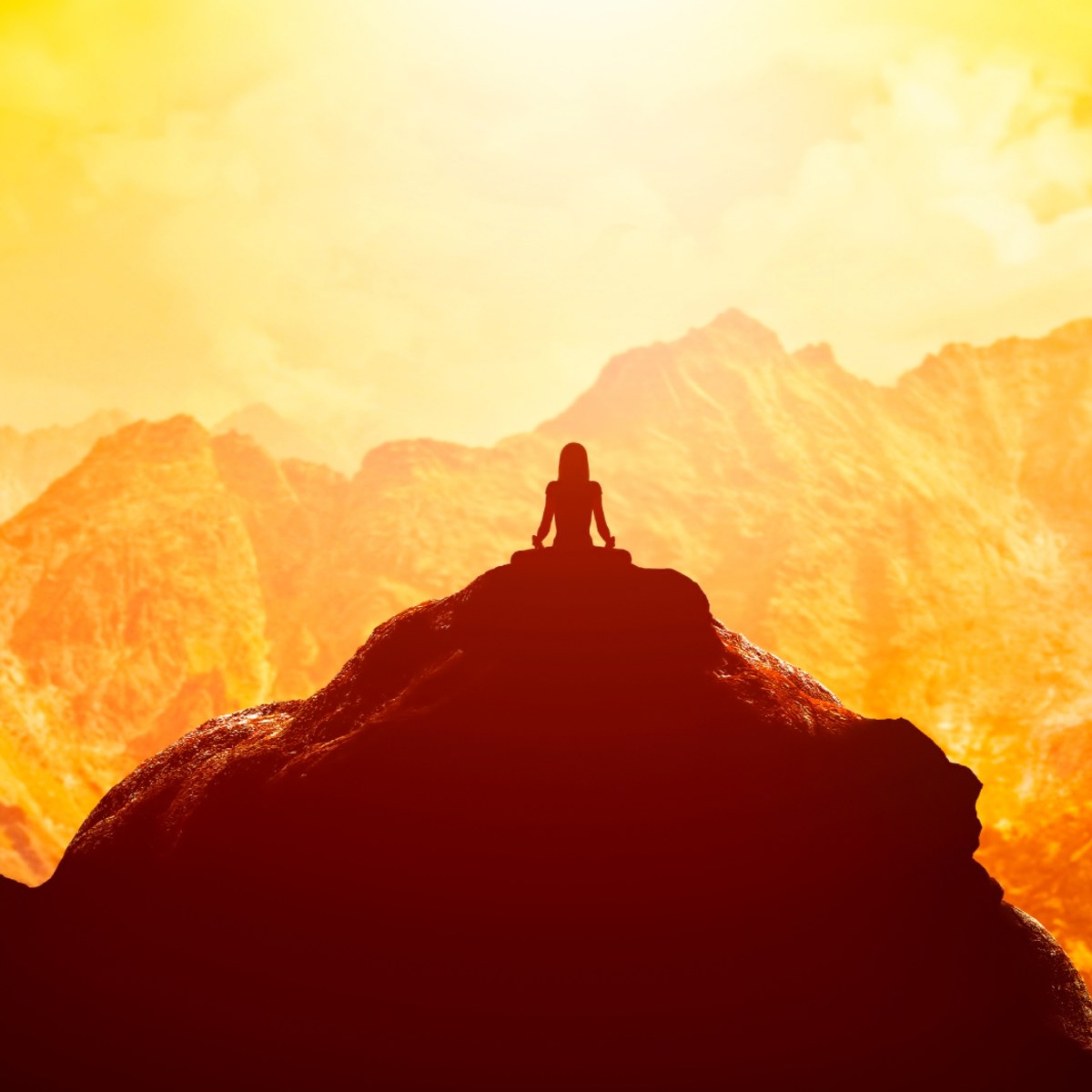 Silhouette of a person meditating on a mountain peak against a glowing orange and yellow sunset landscape.