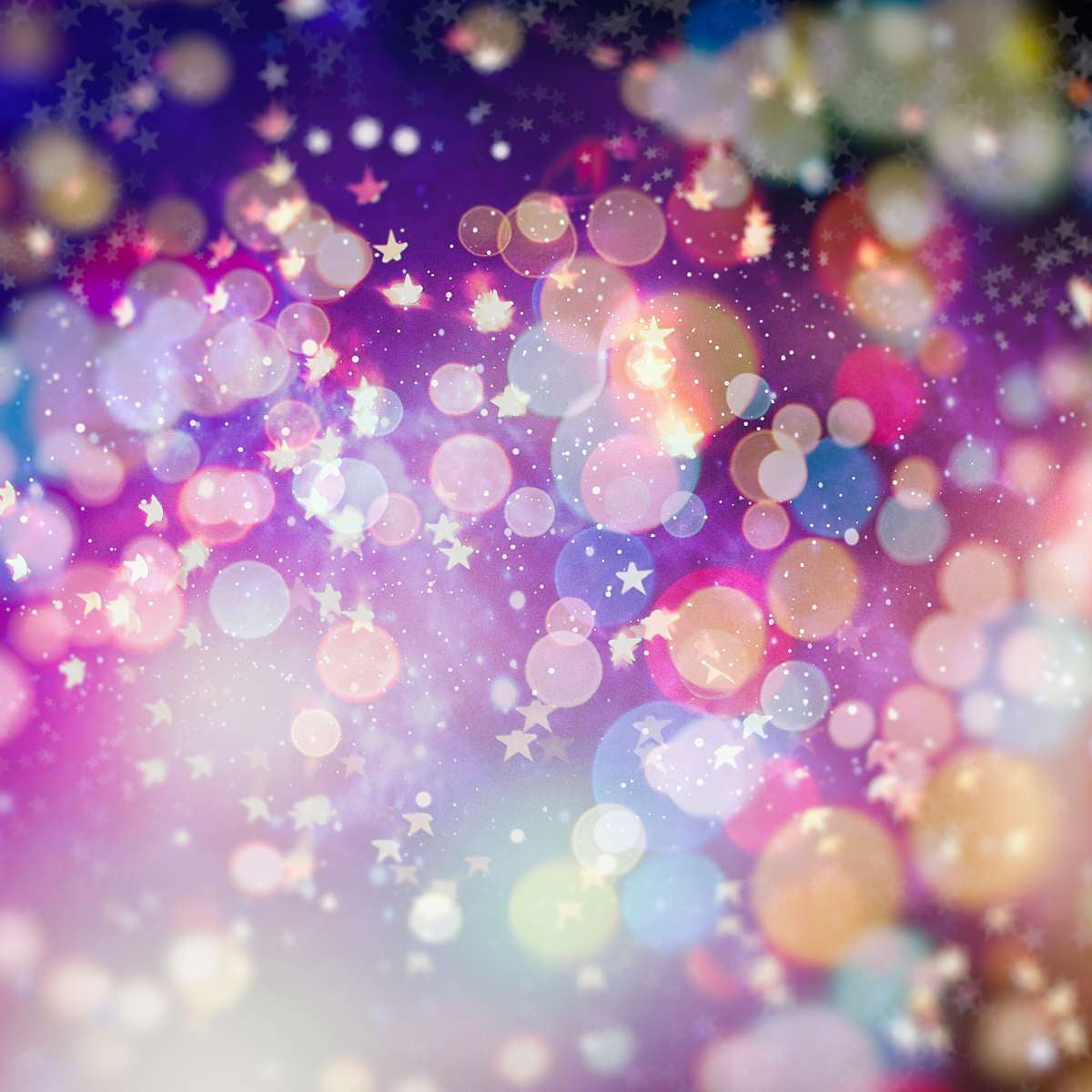 An abstract, brightly coloured bokeh with soft circles of pink, purple, yellow, and blue light.