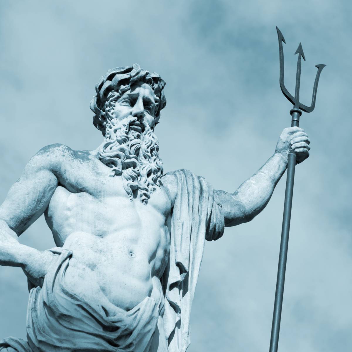 A statue of a Neptune holding a three-pronged trident, shown in a monochrome blue-tone against a cloudy sky.