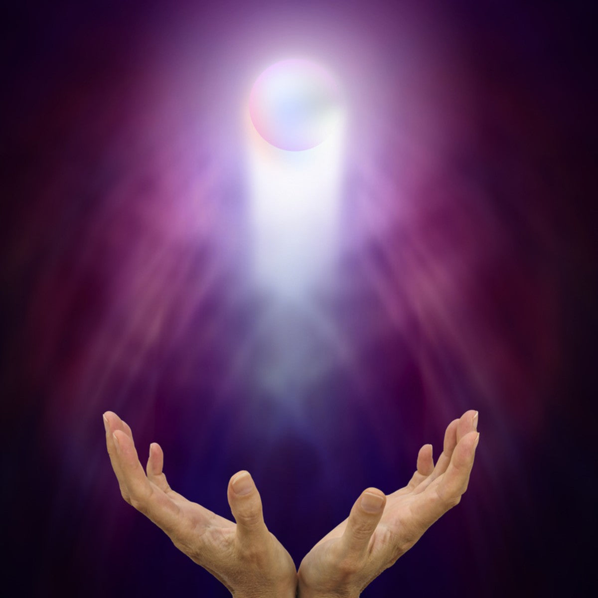 Pair of hands receiving psychic development Reiki energies from a glowing orb above.