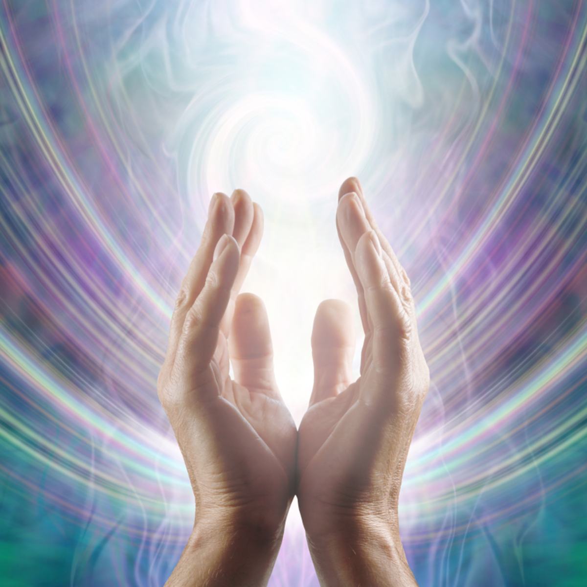 Reiki hands held open with a radiant light and colourful abstract background.