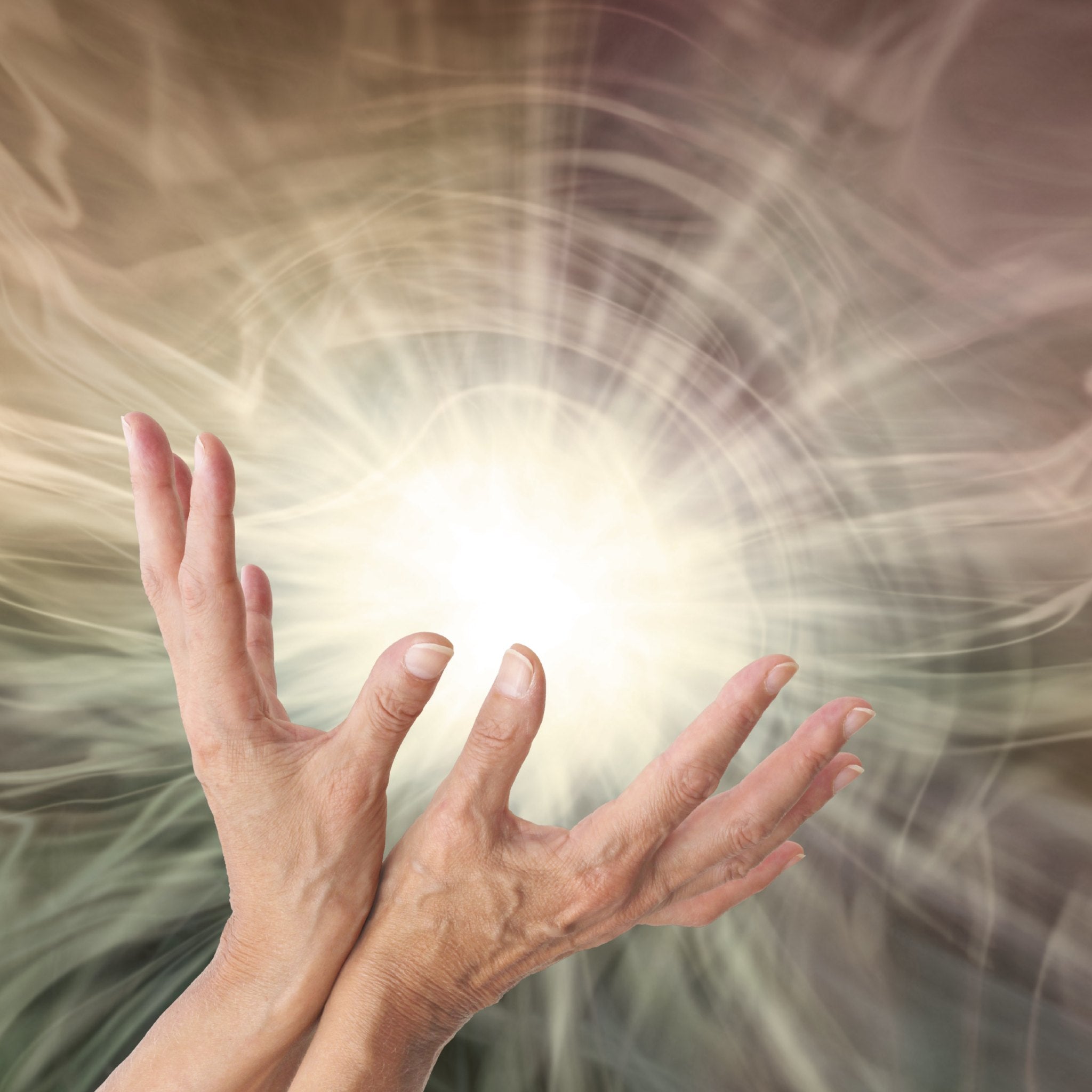 A close-up photograph of a pair of outstretched hands, palms facing slightly inwards, appearing to channel or contain a brilliant, ethereal light source in the centre. The background is a soft, swirling, light-brown and white vortex of energy, signifying the powerful healing abilities of a reiki grand master path alignment dedication.