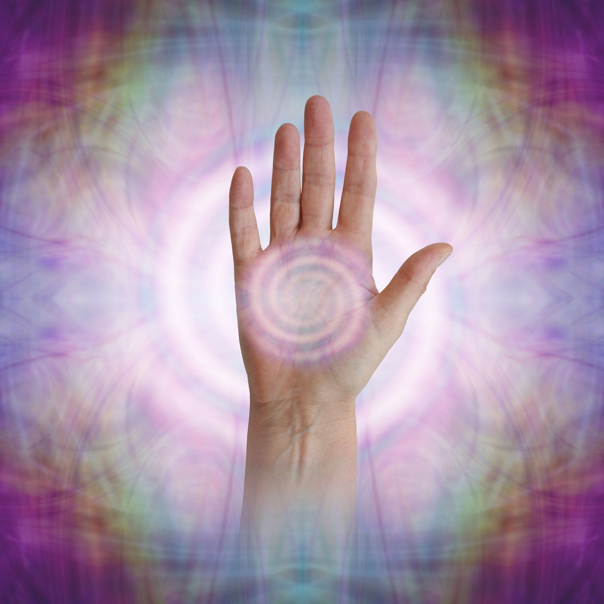 A close-up shot of an open, raised hand set against a bright, swirling background of pink, purple, and green light, depicting an alignment or treatment with Reiki energy. A white, ethereal spiral is centred in the palm of the Reiki master's hand, suggesting the flow of healing energy or a spiritual path of dedication.