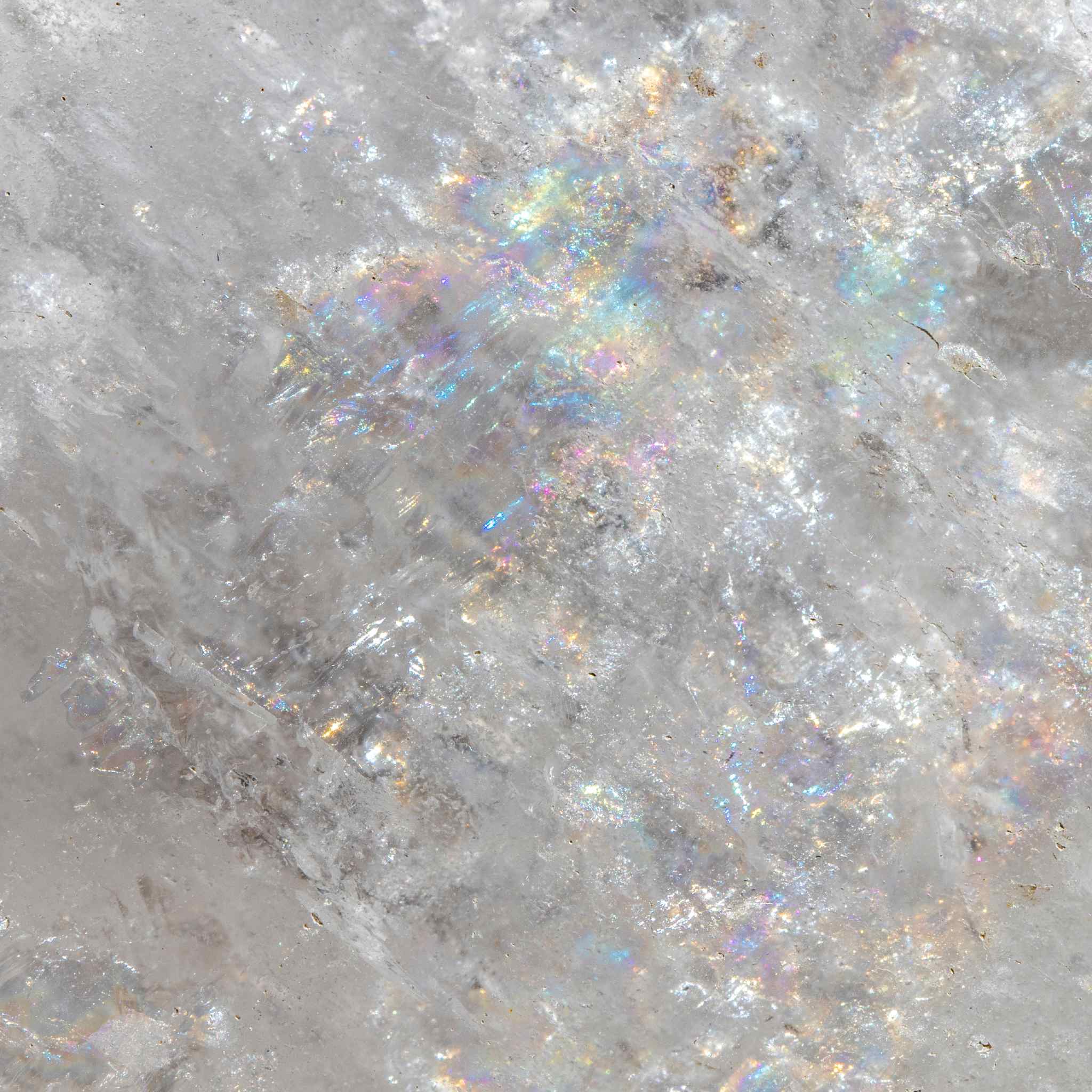 A macro close-up of a piece of clear quartz crystal, showing white shimmering rainbow iridescence, representing Causal Chakra clear quartz amplification.