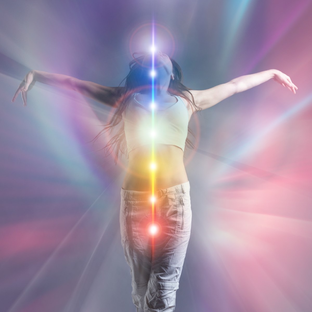Person with arms outstretched and active Kundalini against a colourful, light-filled background.