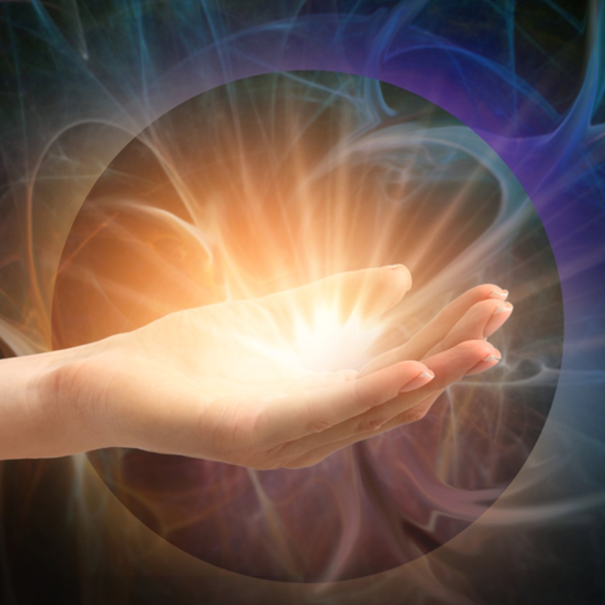 Hand holding a bright Reiki light source with a mystical background.