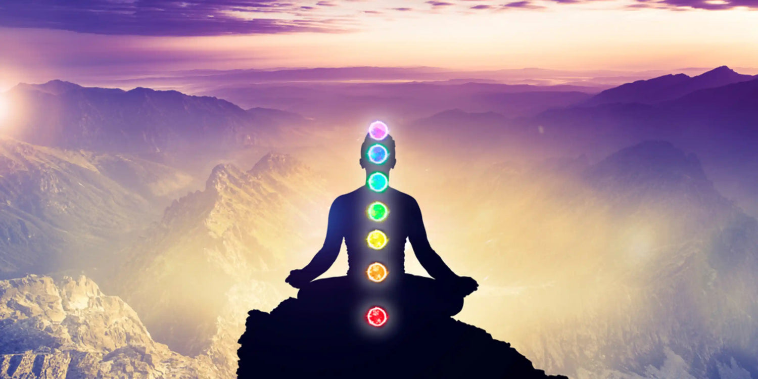 A silhouetted figure in lotus pose on a mountain at sunrise, with glowing chakras suggesting the flow of energy and potential for well-being offered by distant healing treatments in a peaceful setting.