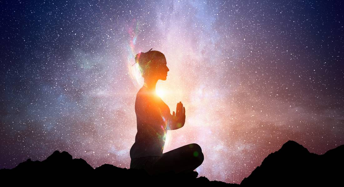 Silhouette of a person in meditation with bright light surrounding them, symbolising a chi ball attunement.