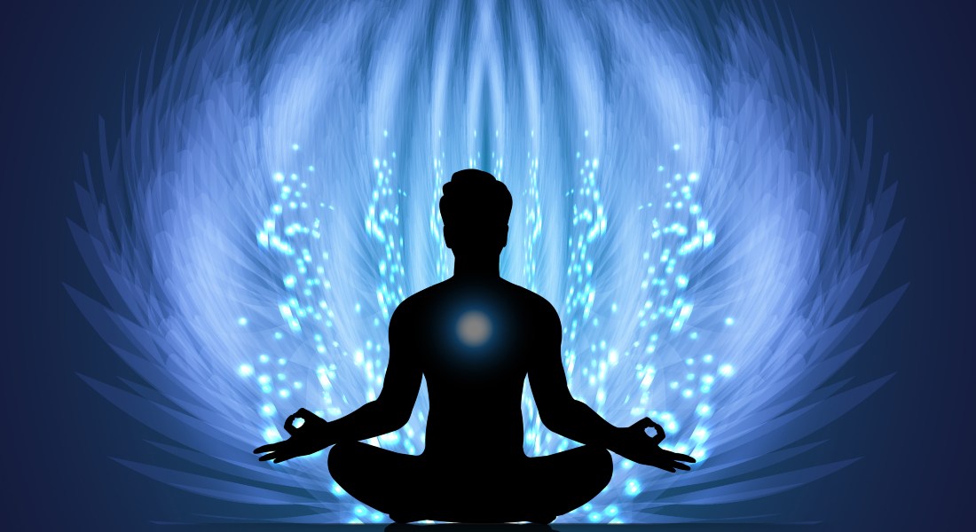 Silhouette of a person meditating with a blue energy field around them.