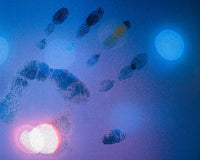 Handprint on glass with blue background representing energetic imprints.