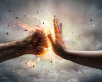 Two hands reaching towards each other with a glowing, fiery explosion between them against a dark background.