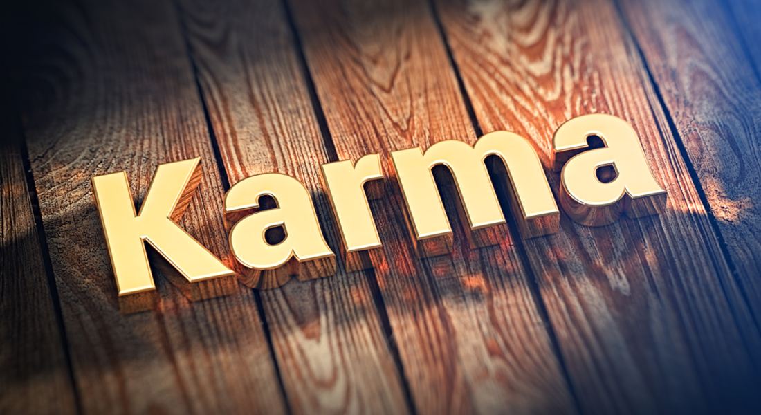 Wooden block letters spelling 'Karma' on a wooden surface.