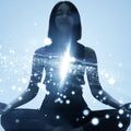 A silhouette of a young woman sitting in a meditative pose, with her heart centre illuminated by an intense burst of white light and sparkling, ethereal particles against a bright, light-blue background.