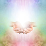 Two hands reaching towards each other against a soft Reiki energy background.