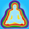 Man in meditation pose with rainbow energy circles on a blue background representing layers of the aura.