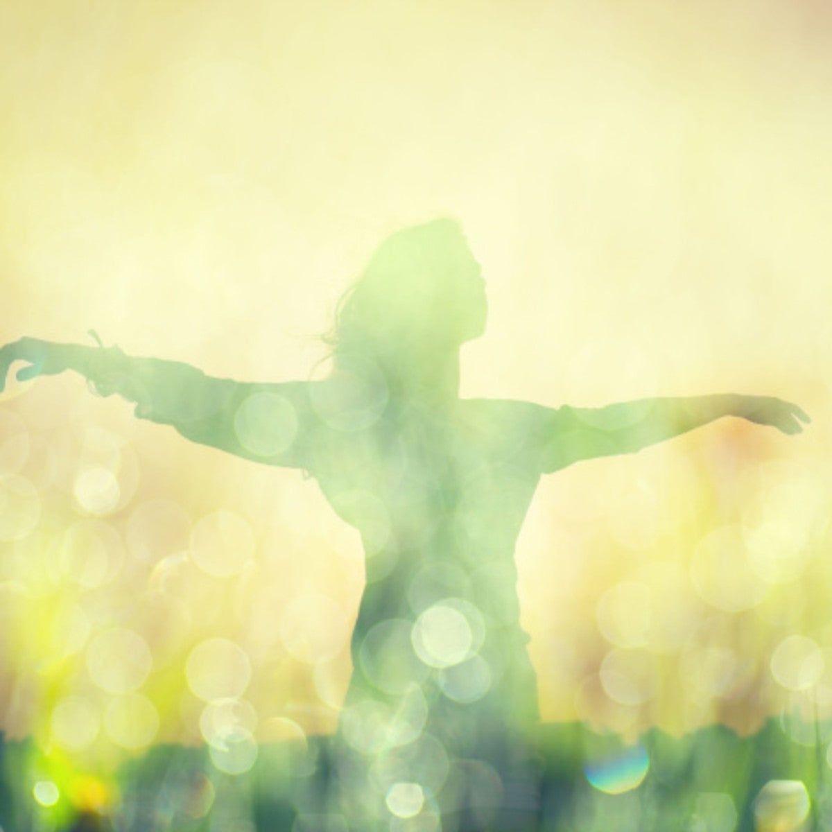 A person with arms wide open in a glowing landscape, representing the spiritual freedom and expression.