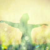 A person with arms wide open in a glowing landscape, representing the spiritual freedom and expression.