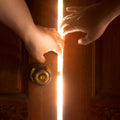 Two hands opening a wooden door with light streaming through. Symbolises energetic clearing, purification, obstacle removal, and spiritual light.