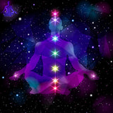 Silhouette of a person in meditation with chakra colours on a starry space background.