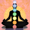 Silhouette of a person in meditation with chakra symbols on a colourful background.
