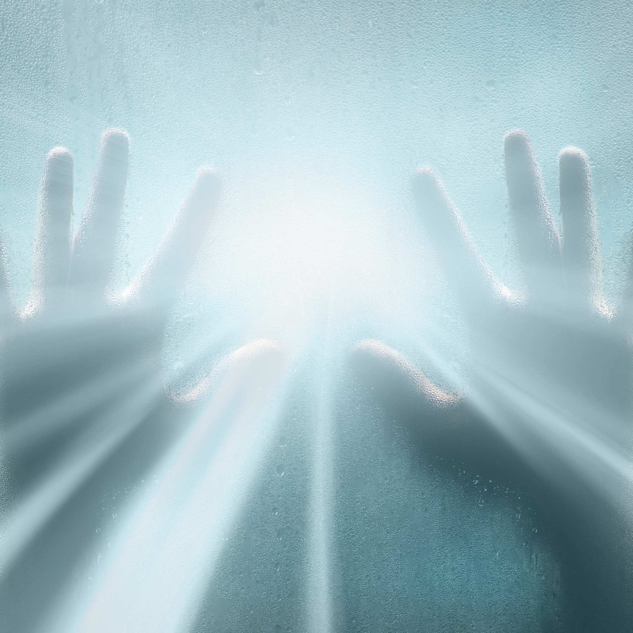 Two hands pressed against a steamy or frosted pane, reaching toward a brilliant, blurry white light, symbolising clairtangency and psychometry.