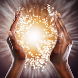 Two hands raised towards a bright, glowing light source with a radiant effect.