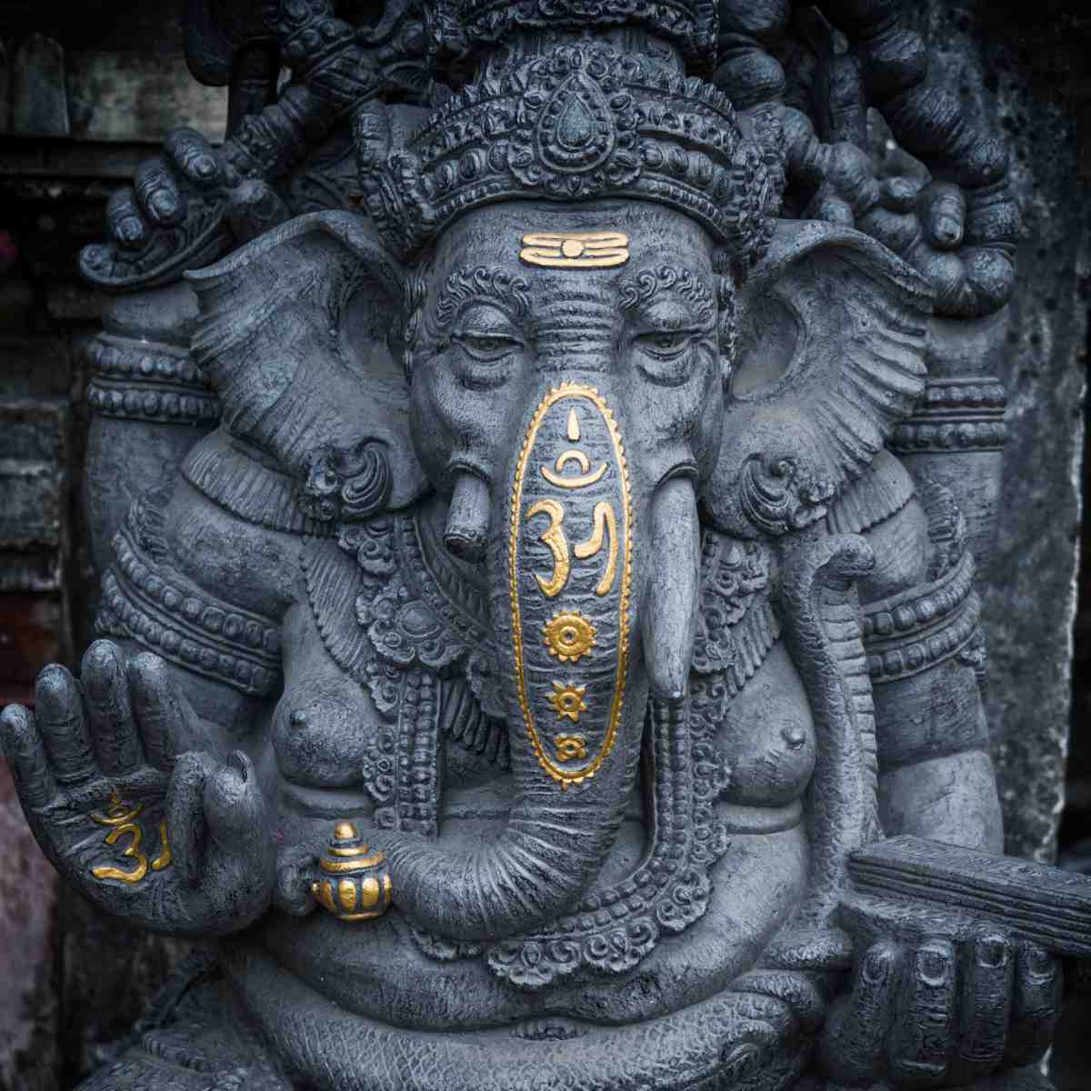 Statue of Lord Ganesha with elephant head and ornate details, featuring gold accents.