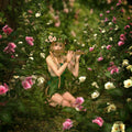 A mystical forest pixie in a green dress and flower crown playing a wooden flute among pink and white rose bushes.