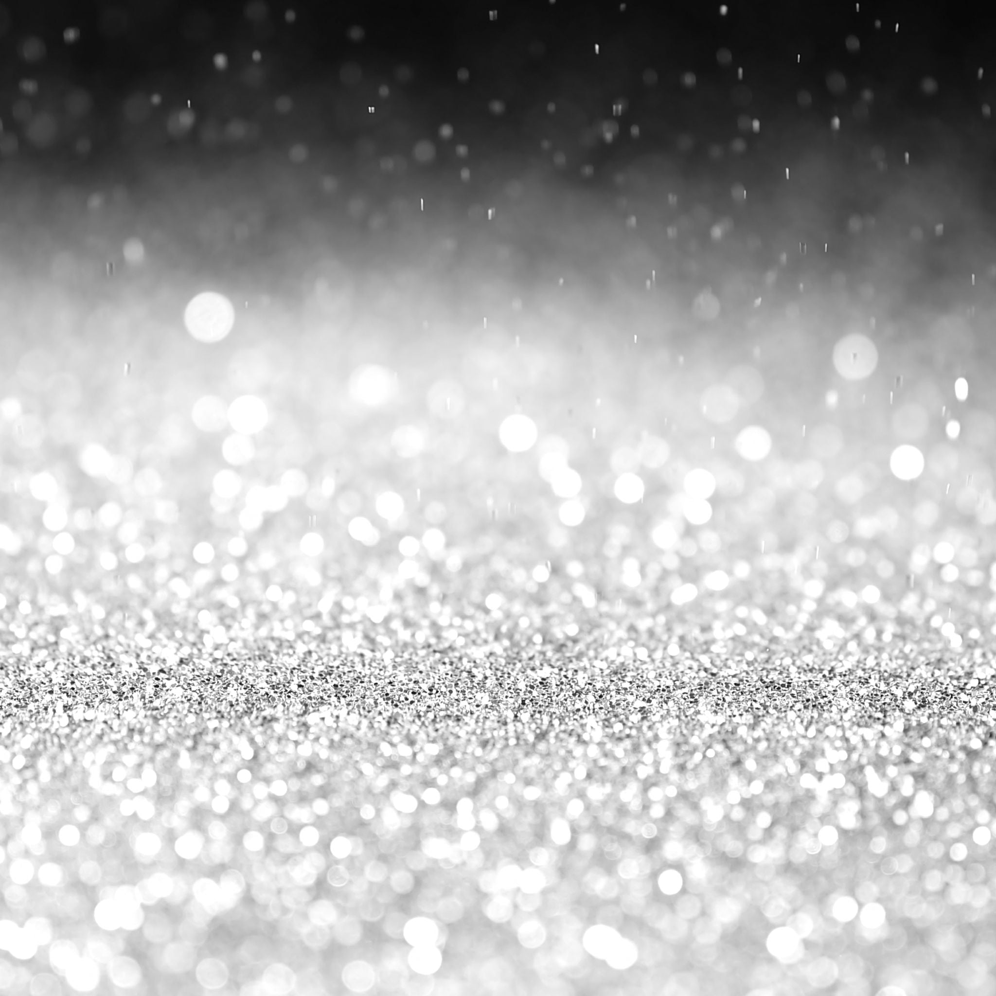 A beautiful abstract image of bright, silvery platinum glitter and bokeh lights fading into a dark background, representing platinum energy connections.