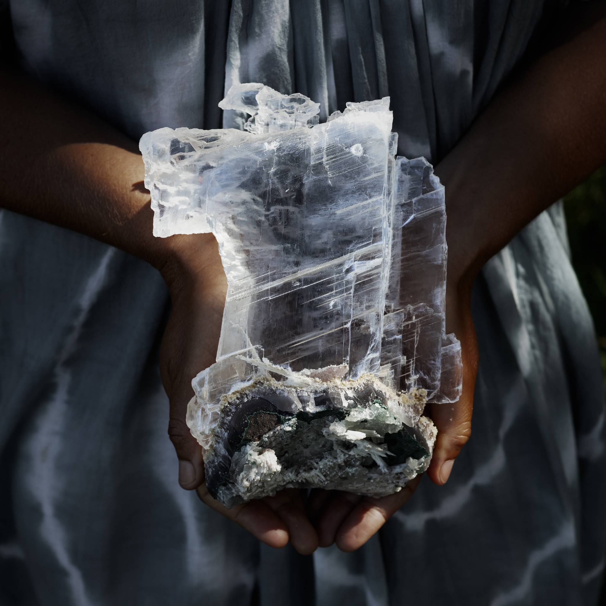 Person holding a large selenite crystal.