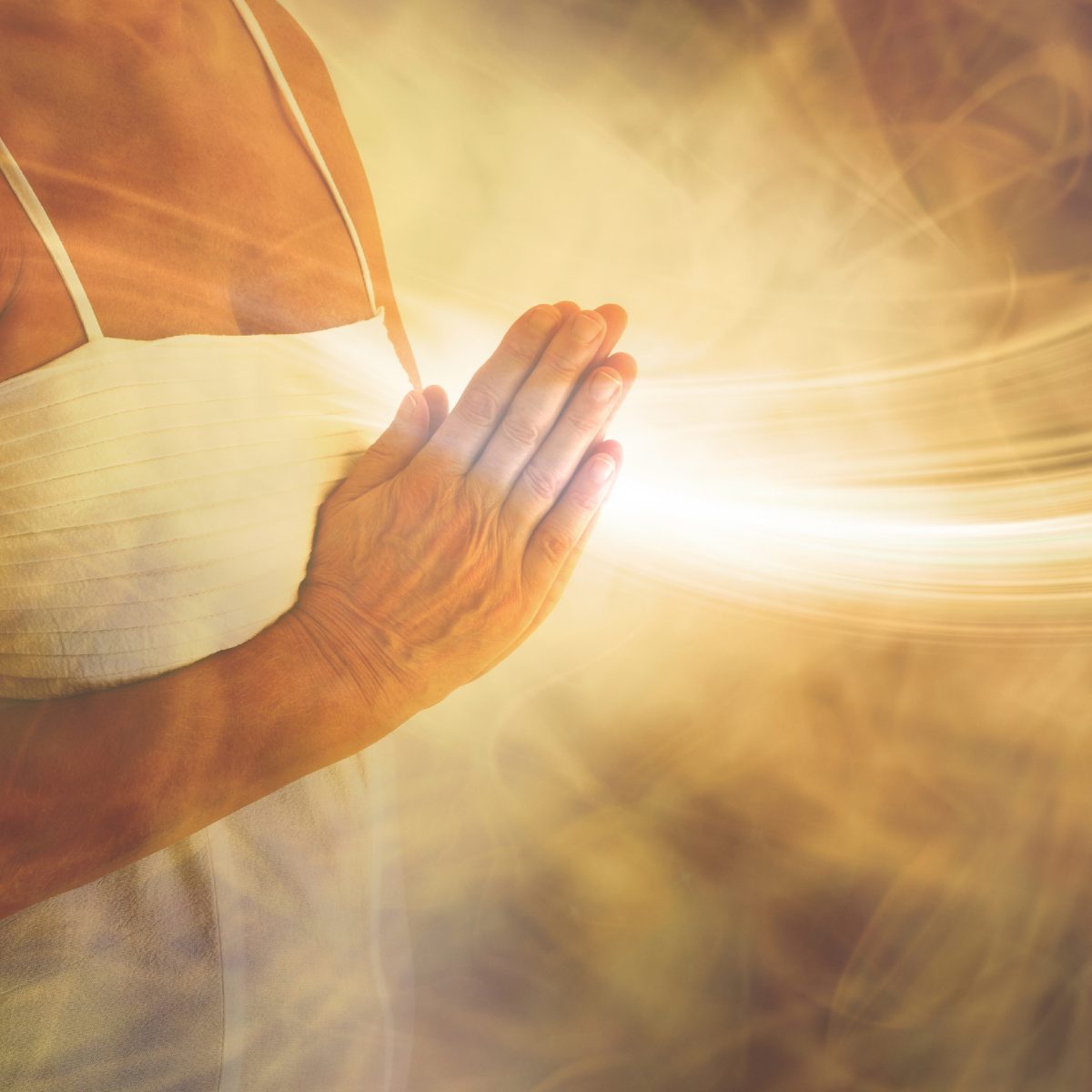 Person holding hands together with a warm glow of source energy flowing.
