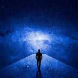 Silhouette of a person standing on a path leading to a bright blue galaxy.