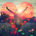 A double-exposure image where a person with their arms raised in a gesture of freedom stands silhouetted against a sunset, surrounded by trees and a field. The scene is framed inside a large, glowing red heart shape, with smaller hearts scattered in the foreground.