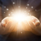 Two hands holding a bright light source with star-like sparkles on a dark background.