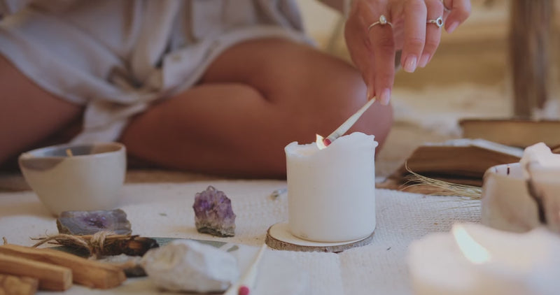 Video of a woman lighting incense in a sacred space with candles and crystals, creating a calming atmosphere for energy healing and spiritual practice. Represents Blissful Light's distant (remote) attunements and energy healing treatments.